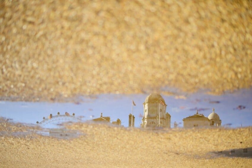 The Horse Guards Parade and London Eye reflected into a puddle.