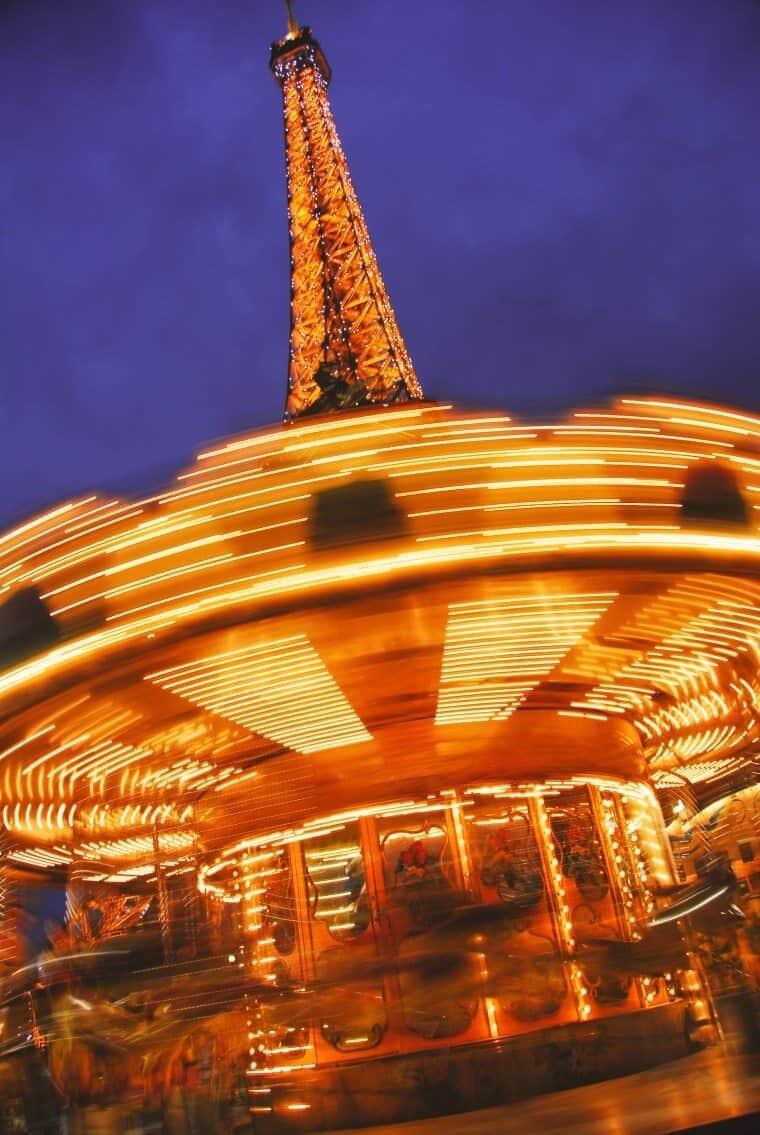 The Eiffel Tower peeking from behind the Carousel on the banks of the Seine River.
