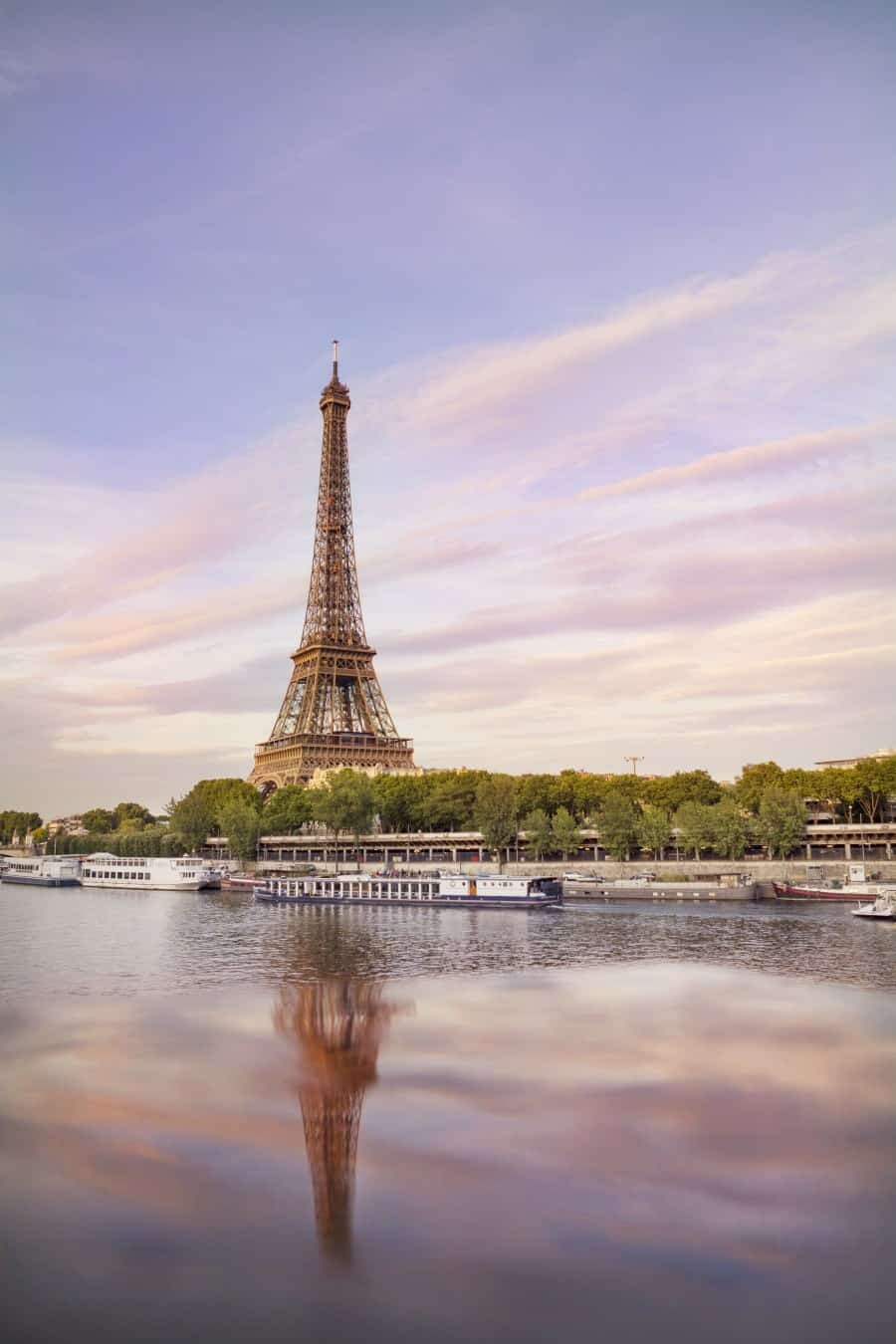 Pont de Bir Hakeim Another one of my favourite locations is this bridge which is perfectly located right near the Eiffel Tower across the River Seine. From Pont de Bir Hakeim you get a direct view towards the Eiffel Tower and there’s usually some gorgeous houseboats moored along the river to add something extra to your shot. The bridge itself has some shiny black railings that are great to use for creating your own reflections by spilling some water and making little puddles! The bridge has a central section with ornate arches that repeat their way along under the railway. This is a great subject to use for framing the Eiffel Tower and also capturing people passing by on their bicycles. Photo Tip: Take a water bottle to create puddles along the railings, the surface is perfect for creating reflections so you don’t even need to wait for a rainy day! When to visit: This is one of those spots that’s rarely popular at sunset so it’s a great time to venture away from the crowds of Trocadero and find yourself a great perspective to watch the sky change colours above the Eiffel Tower.